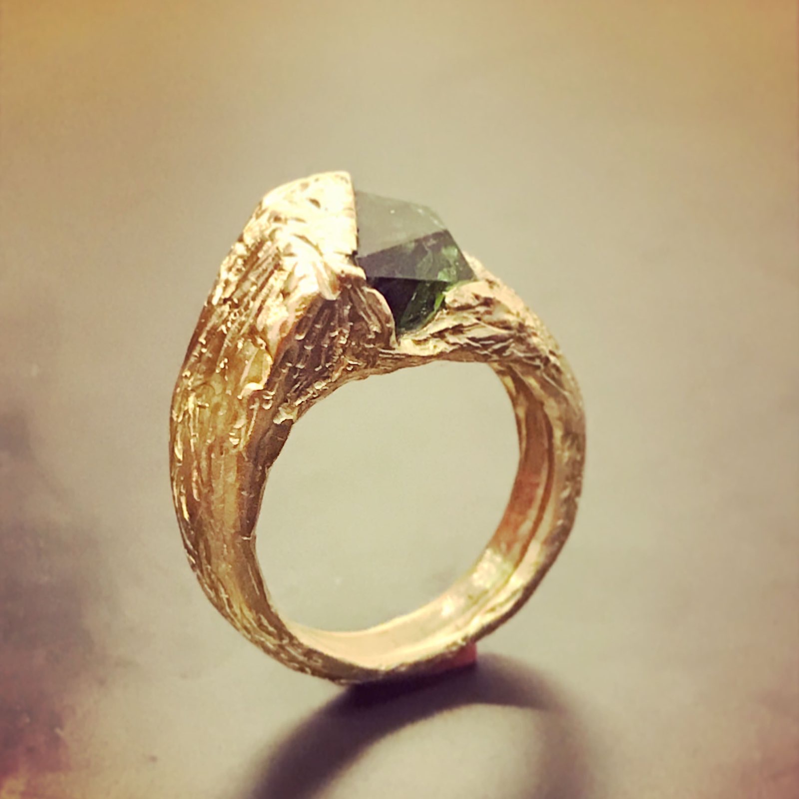 Anillo con piedra verde engastada en oro trabajado a mano