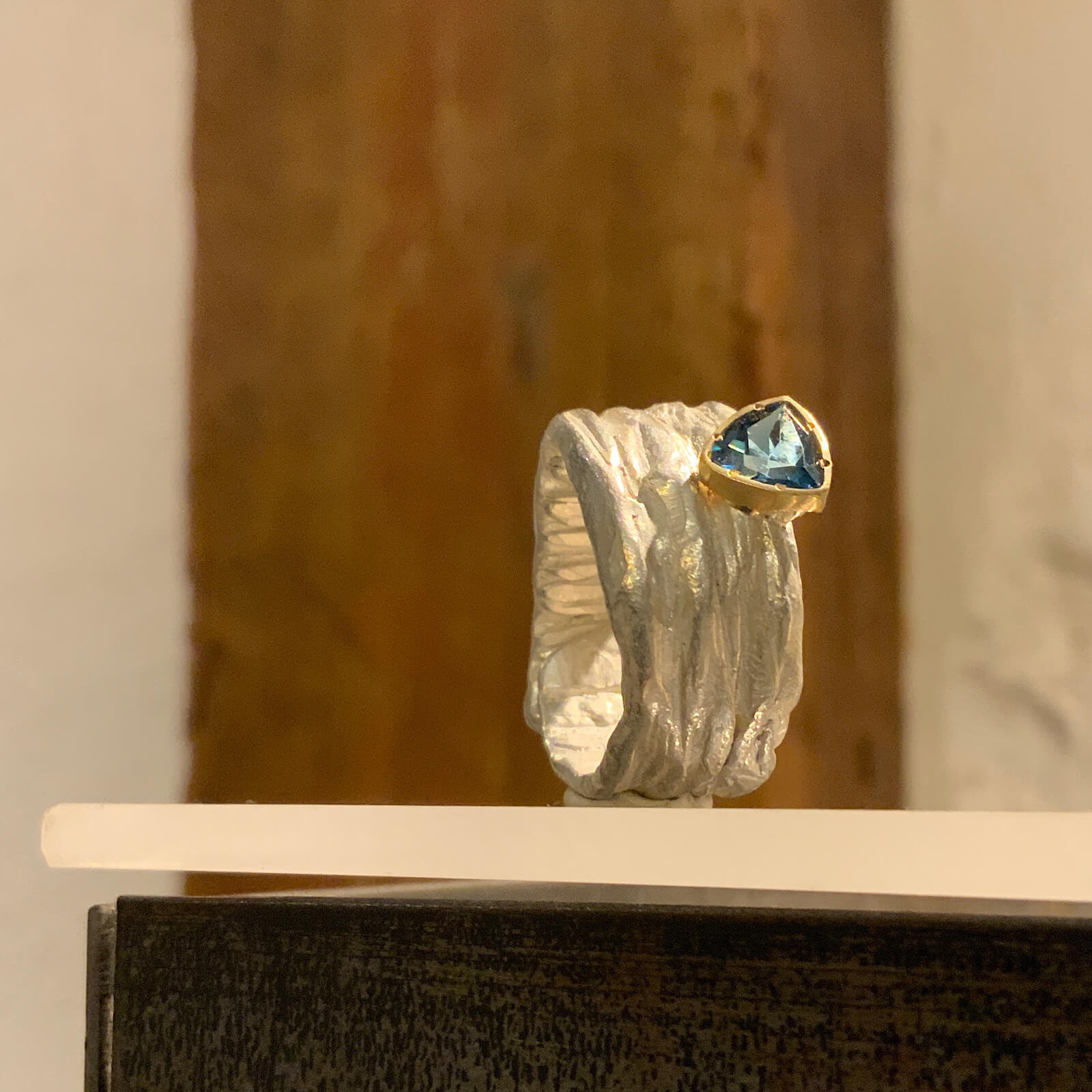 Anillo con piedra azul intensa engastada en plata y oro
