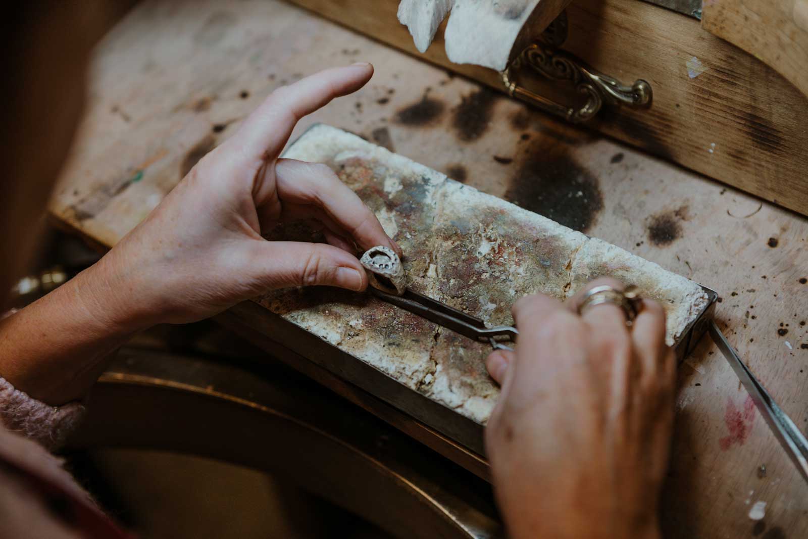 Manos de Maitena Ganboa trabajando un anillo a medida sobre el banco de taller